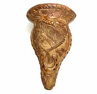 Front view of carved gourd ornament showing detailed leaf and figure carvings with visible 'RS' marking.