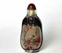 Front side of glass snuff bottle showing a bird perched on an orange and red flower branch with Chinese characters.