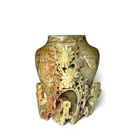 Front view of carved soapstone pen holder featuring detailed floral carvings and natural color variations