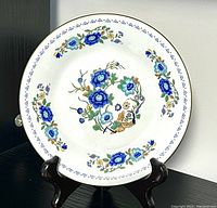 Front view of vintage Aynsley bone china dish on stand, showing blue floral pattern with green leaves and brown accents.