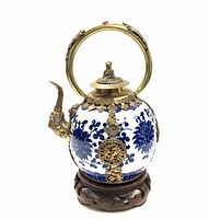 Front view showing spout, body and decorative mounts