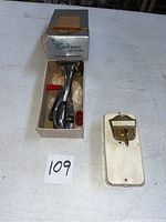 Hudson can opener and Nutone doorbell displayed on table, includes original box for can opener and doorbell mounting plate