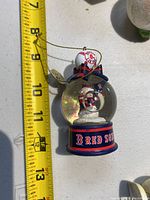 Boston Red Sox snow globe ornament with two snowmen inside. Measures about 4 inches tall.