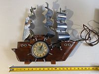 Ship-shaped wooden clock with metal sails, measuring about 23 cm long, includes electric cord