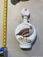 White ceramic bottle with bird painting and stopper, approx. 22 cm tall