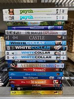 Two stacks of DVDs and Blu-rays showing various movie titles and TV series seasons on shelf.