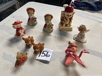 Photo showing all vintage Christmas figurines including angels, elves, and reindeer on white table.