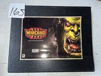 Black box set with Warcraft Reign of Chaos Collector's Edition cover showing an orc's face.