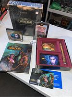 Large black World of Warcraft Collector's Edition box, game manual, and game discs displayed with collector's packaging insert