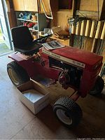 Side view of red Wheel Horse SK-486 garden tractor showing chassis, seat, and front wheel