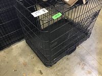 Metal wire pet crate showing entire structure with black plastic bottom tray in place, front door visible.