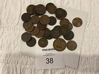 Thirty copper tokens spread on white cloth, lot label visible