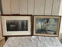 Both framed prints displayed side by side showing full views with visible scratches on frames.