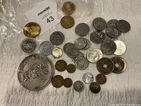 Overview photo showing various Canadian coins and tokens including a 'Lucky Penny' token with a buffalo design, several smaller coins, and two square-holed tokens.