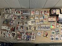 Overall spread of hockey and baseball cards on beige cloth in stacks and piles