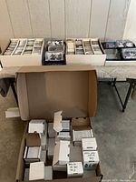 Overview of multiple cardboard and white storage boxes with loose cards on table