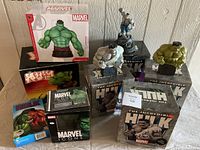 Overall view of eight sealed boxes and three open statues grouped on table