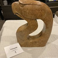 Front view of amber-toned abstract eagle sculpture on fabric