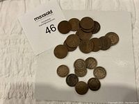 Overhead view of entire lot on white board showing mixed one- and two-cent coins and one five-cent Shield Nickel