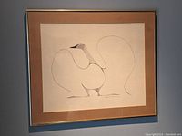 Framed artwork showing the full print with beige matte and thin gold frame hung on a wall.