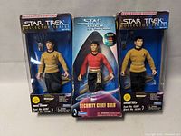 Three Star Trek action figures in original boxes: two Captain Kirk in yellow shirts, one Security Chief Sulu in red shirt.
