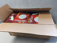 Open cardboard box containing two sealed Pyle speaker system boxes each holding a pair of speakers.