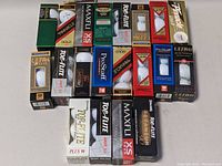Top view of 20 golf ball sleeves laid out showing brands and models including Top-Flite, Pinnacle, Titleist, Maxfli, and Wilson in mostly unopened packaging.