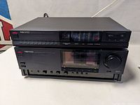 Front view of Nikko NA100 integrated stereo amplifier and Nikko NA100 stereo tuner stacked on each other showing controls and display.