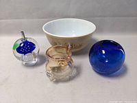 Pyrex 403 mixing bowl alongside three distinct glass art pieces: fish-shaped clear glass piece, blue glass sphere, and clear glass orb with fish inside.