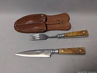 Full view of knife and fork with leather holder, showing utensils alongside the pouch.
