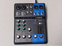 Top view of Yamaha MG06 compact mixer showing all input channels, gain, EQ, level knobs, stereo output and headphone output.