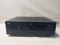 Front view of Yamaha STR-5540 receiver showing power button, display with FM frequency, large volume control, headphone jack, and control buttons.