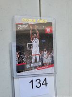Front side of the 2017/18 Panini Prestige #173 OG Anunoby rookie basketball card inside a plastic holder, showing the player mid-jump shot with rookie indicators.
