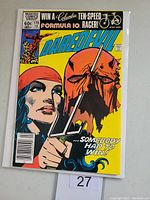 Front cover of Daredevil #179 comic book featuring Elektra holding a sai and a severed red mask.