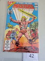 Front cover of Masters of the Universe #1 Marvel comic book featuring He-Man holding weapons with action scene background