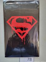 Front view of the black bag packaging with red dripping Superman logo