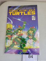 Front cover of the Teenage Mutant Ninja Turtles #4 comic book showing the four turtles with weapons in bright colors against a purple background.