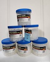 Six plastic containers of hollow tile spacers stacked and arranged. Labels show sizes 1/8 inch and 3/16 inch. Each container holds 500 pieces.