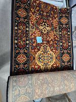 Full view of rolled and unrolled carpet runner showing intricate patterns and colors