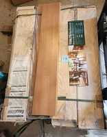 Overview of strapped hardwood flooring cases and sample plank on top