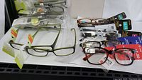 Overview photo of 18 pairs of reading glasses, 12 Allure +2.50 in olive green, black, and other colors, 6 EyeCare with various lens strengths and frame colors.