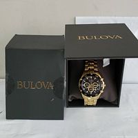 Watch in open Bulova box next to outer box