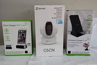 Photo showing all three items: EZVIZ C6CN Internet PT Camera box in the center and two dock charger boxes on each side. All in original sealed packaging.