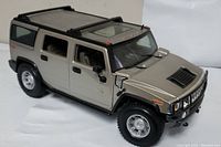 Front-side view of the silver Maisto Hummer H2 1:18 diecast model car, showcasing details like doors, wheels, and roof rack.