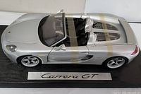 Top angled view showing overall shape, silver finish, and Carrera GT plaque on black base.