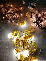 Overall view of three sets of patio pool lights powered on, showing clear and yellow bulbs emitting light on floor.