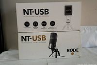 Box front of RODE NT-USB professional USB microphone showing brand and features icons including studio quality, headphone output, USB connectivity, desk stand & pop filter included.