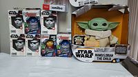 Front view of Star Wars and Avengers Bitty Boomers, Mandalorian The Child plush, and Nintendo Amiibo figures in original packaging.