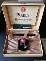 Box open with pen, ink bottle, and warranty booklet inside original Pelikan box