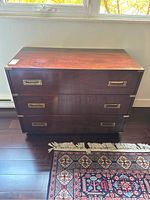 Front view of three-drawer dresser with brass hardware